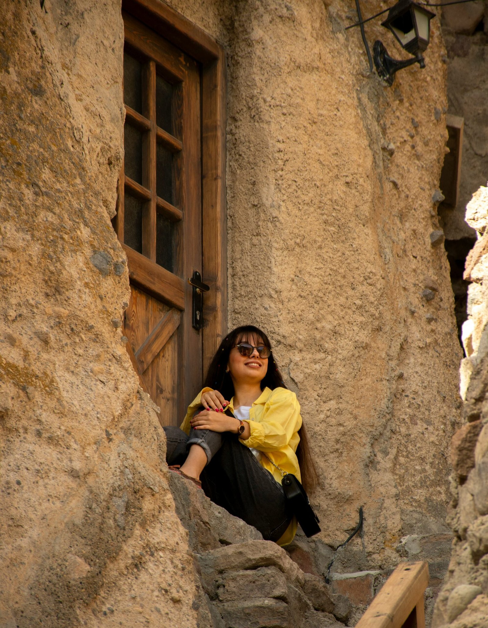 A woman sitting on a ledge in a stone building